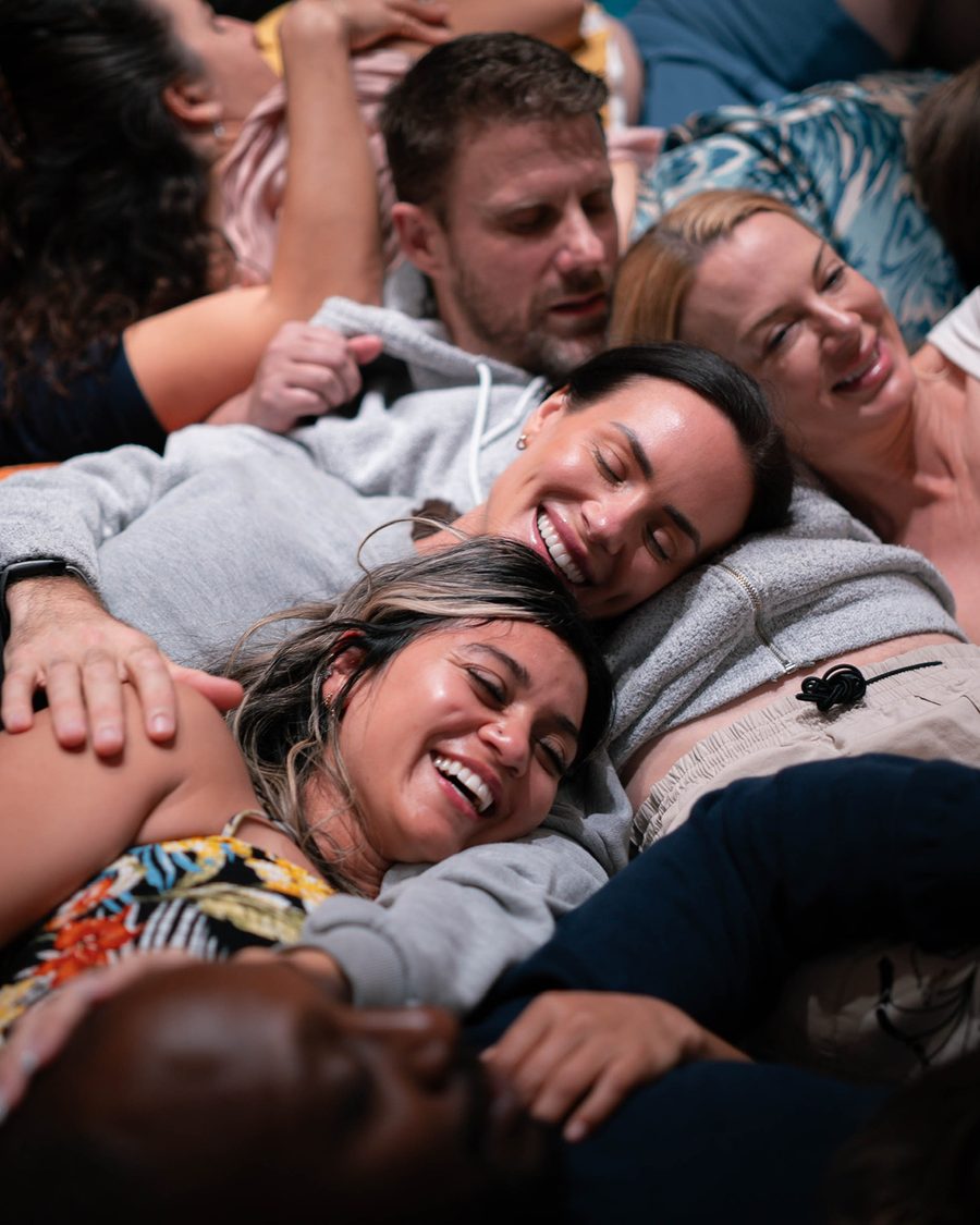 Guests laughing together, resting on one another